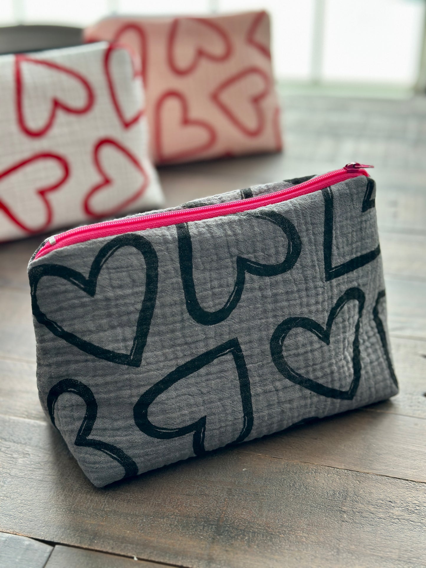 gray zipper pouch with black hearts pattern
