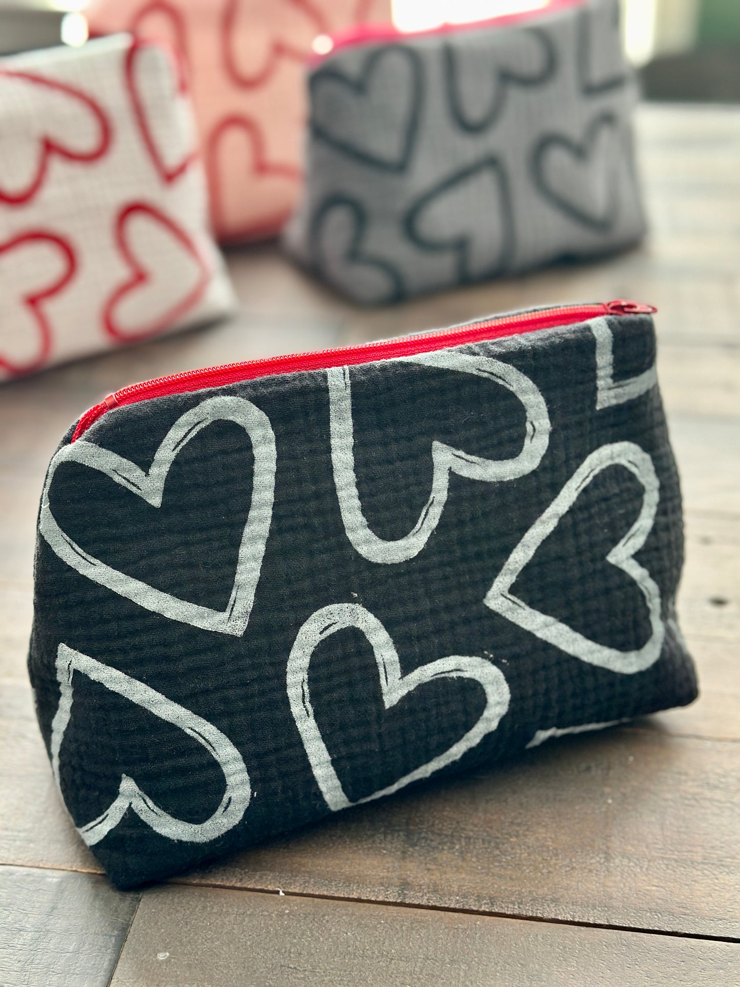 black zipper pouch with white hearts pattern